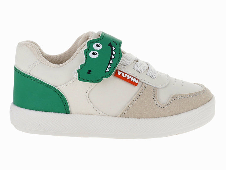 Tenis infantiles color beige con detalles en verde y un parche de dinosaurio en la lengüeta.