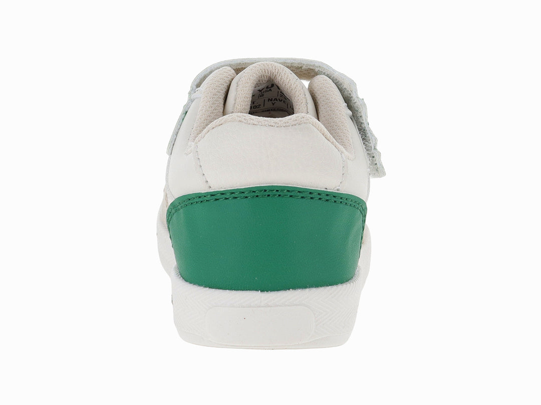 Tenis infantiles color beige con detalles en verde y un parche de dinosaurio en la lengüeta.
