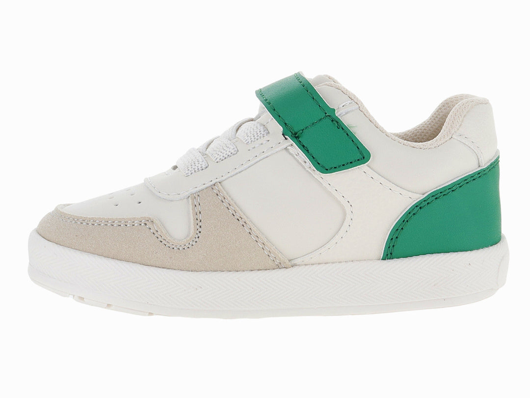 Tenis infantiles color beige con detalles en verde y un parche de dinosaurio en la lengüeta.