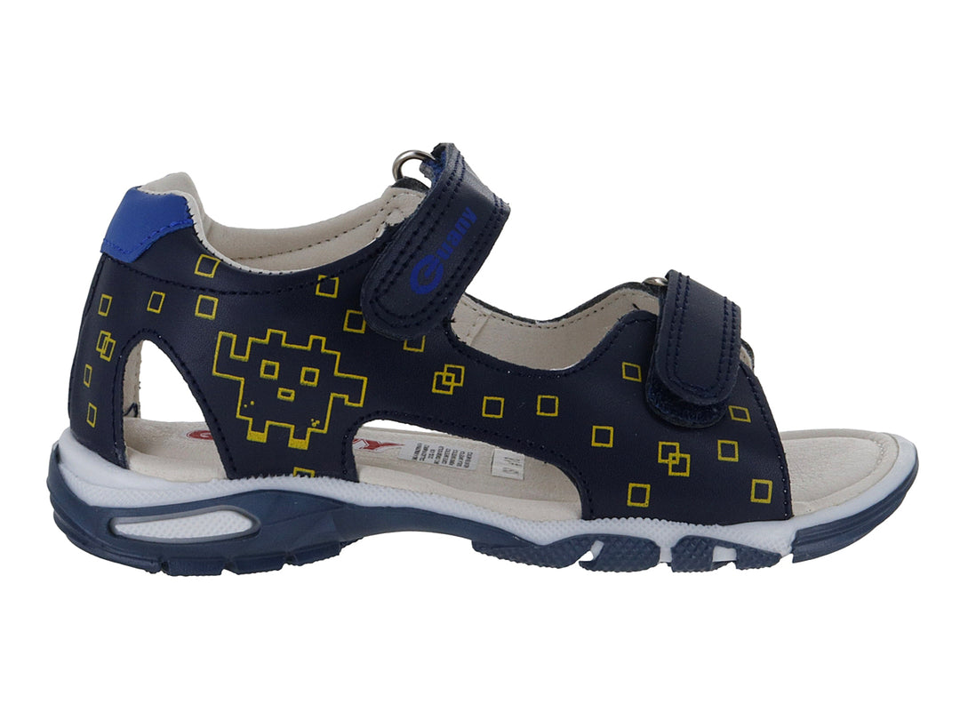 Sandalia infantil azul marino con detalles amarillos en forma de píxeles y cierre de velcro.