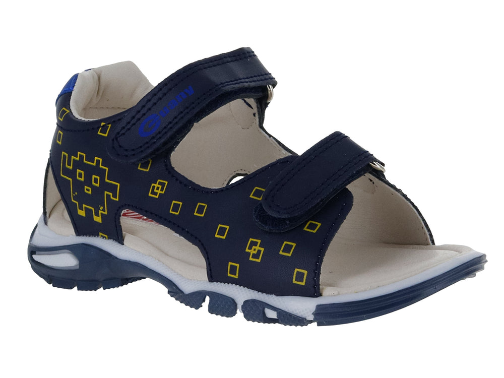 Sandalia infantil azul marino con detalles amarillos en forma de píxeles y cierre de velcro.