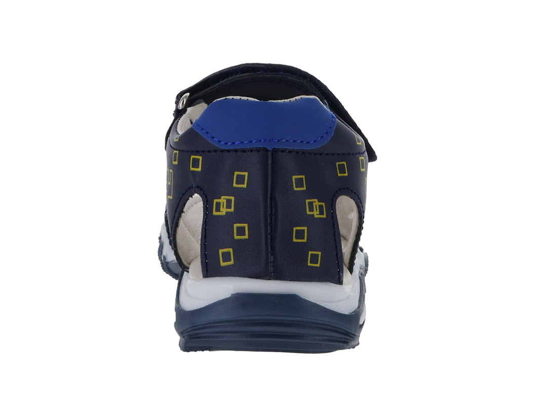 Sandalia infantil azul marino con detalles amarillos en forma de píxeles y cierre de velcro.