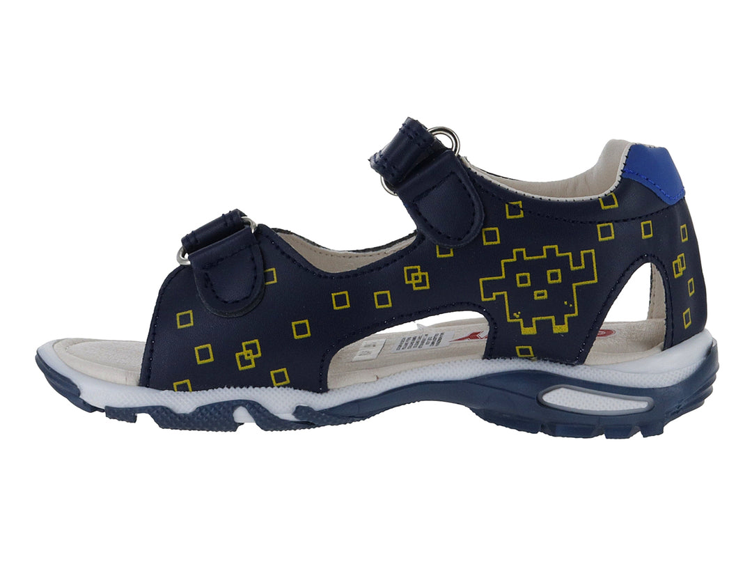 Sandalia infantil azul marino con detalles amarillos en forma de píxeles y cierre de velcro.