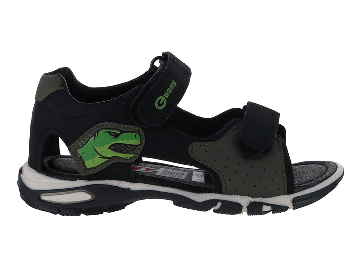 Sandalia infantil color negro con detalles verdes, dibujo de dinosaurio y suela blanca.
