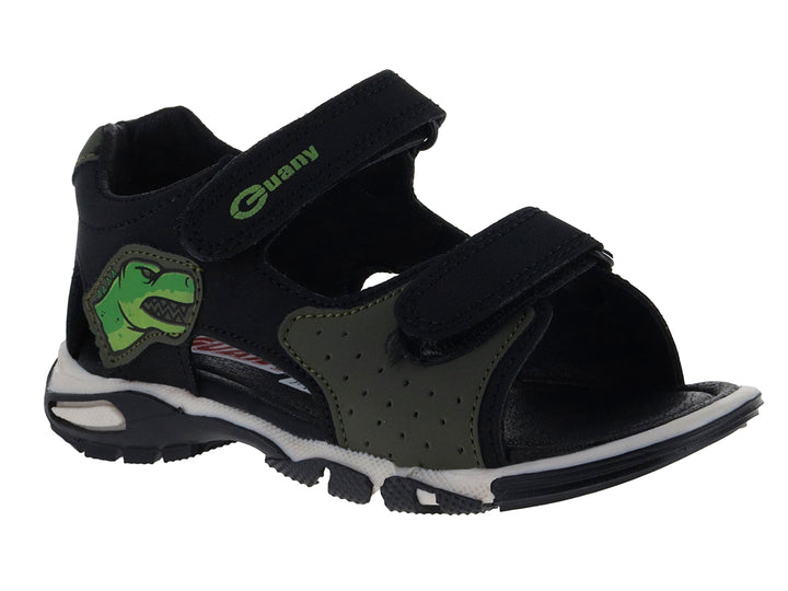 Sandalia infantil color negro con detalles verdes, dibujo de dinosaurio y suela blanca.