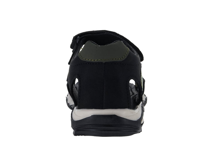 Sandalia infantil color negro con detalles verdes, dibujo de dinosaurio y suela blanca.