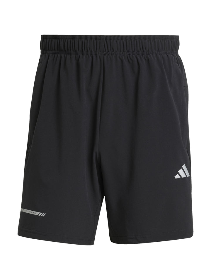 Hombre vistiendo shorts deportivos Adidas color negro con logo blanco en la pierna izquierda.