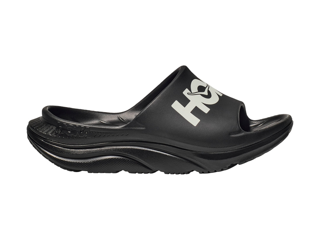 Sandalia deportiva HOKA Ora Athletic Slide en color negro con logotipo blanco en la banda superior.