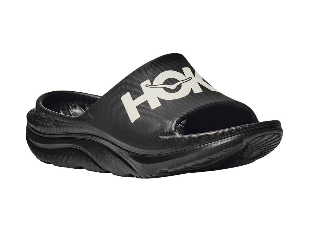 Sandalia deportiva HOKA Ora Athletic Slide en color negro con logotipo blanco en la banda superior.
