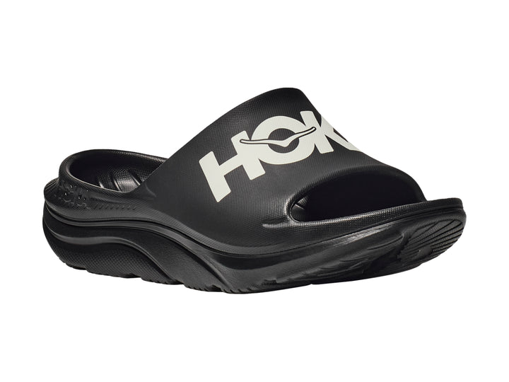 Sandalia deportiva HOKA Ora Athletic Slide en color negro con logotipo blanco en la banda superior.
