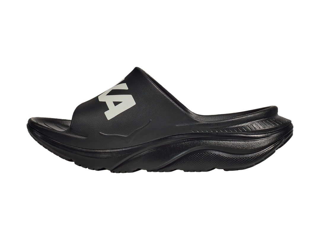 Sandalia deportiva HOKA Ora Athletic Slide en color negro con logotipo blanco en la banda superior.