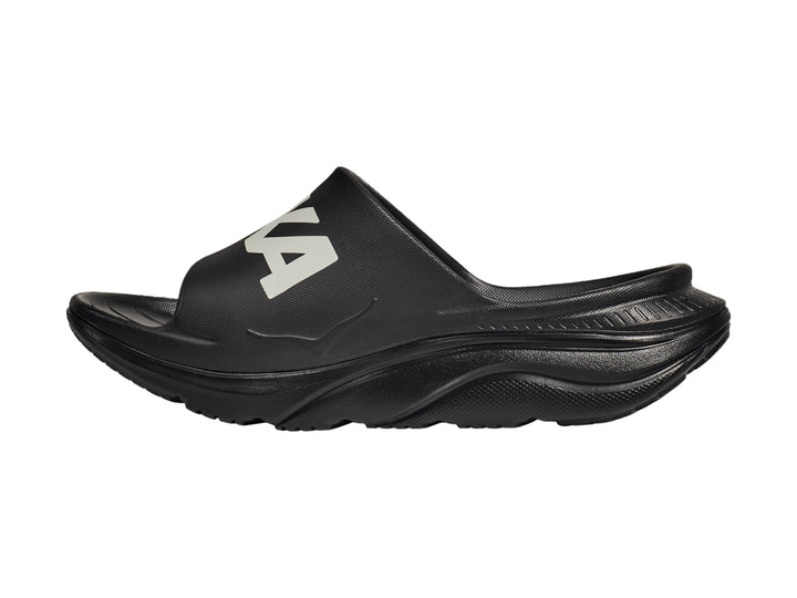 Sandalia deportiva HOKA Ora Athletic Slide en color negro con logotipo blanco en la banda superior.