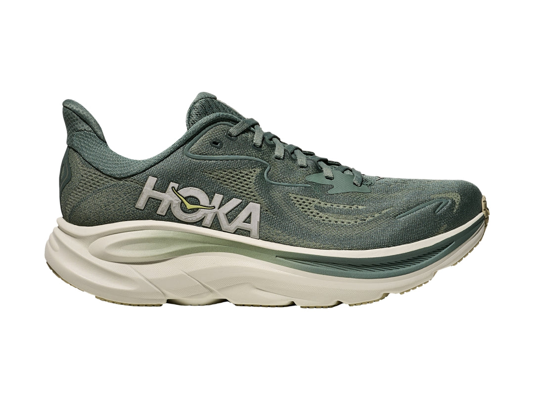 Tenis deportivos HOKA Clifton 10 color verde fern con suela gruesa color crema.