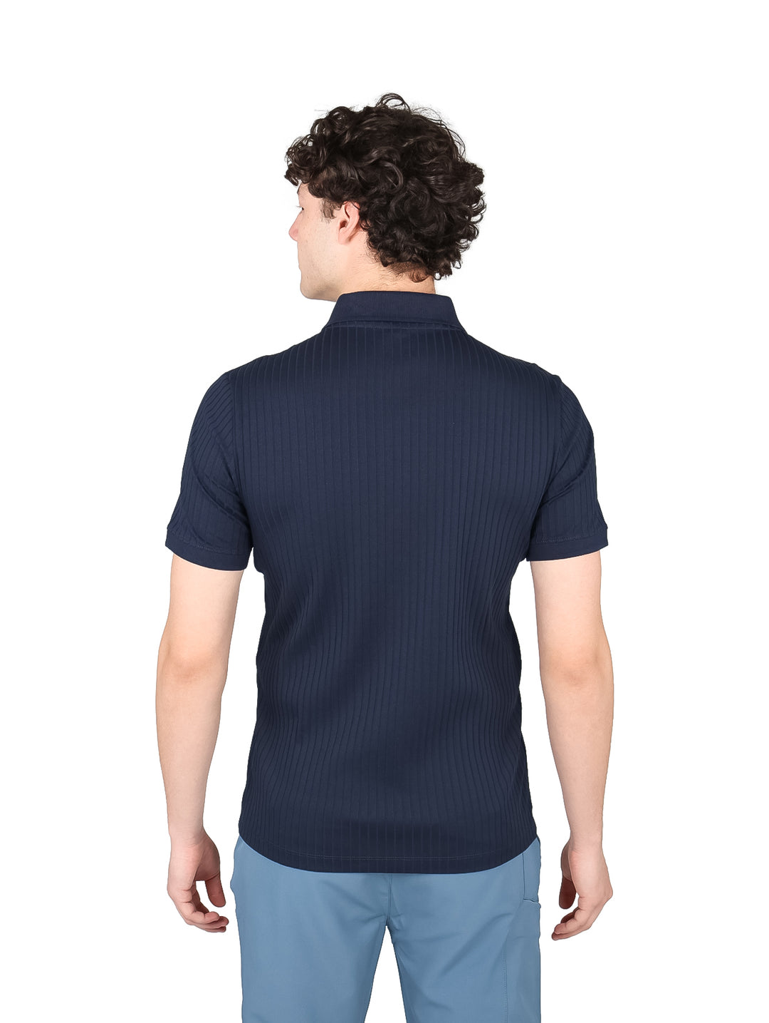 Hombre vistiendo una playera polo azul marino con cuello de cierre y textura acanalada.