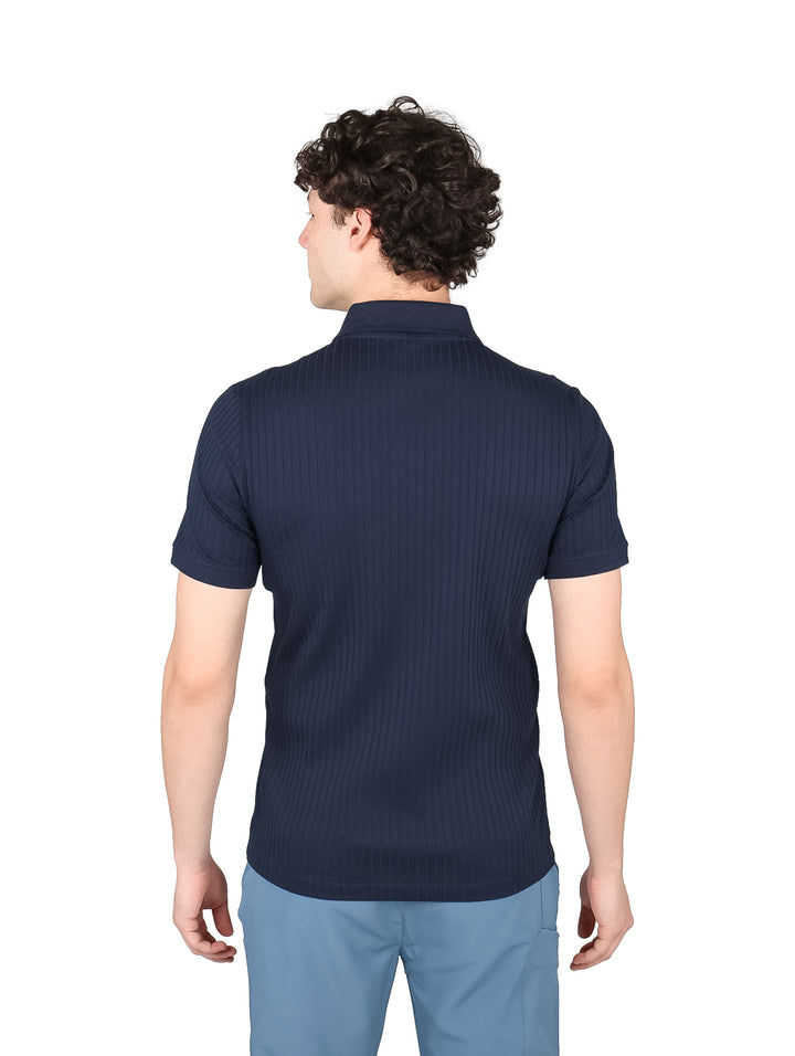 Hombre vistiendo una playera polo azul marino con cuello de cierre y textura acanalada.