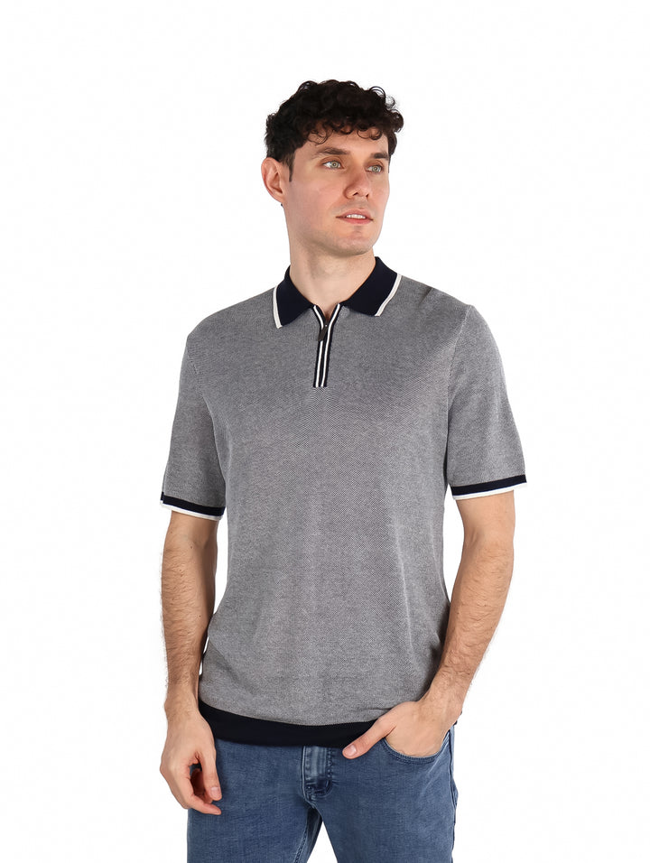 Hombre vistiendo camiseta polo color azul zafiro oscuro con detalles contrastantes en el cuello y mangas.