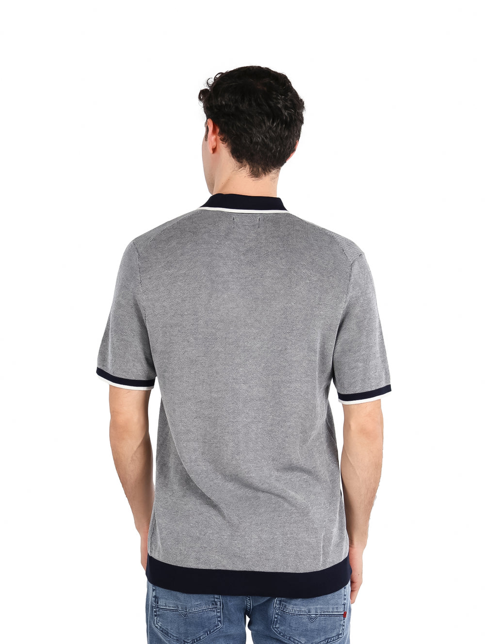 Hombre vistiendo camiseta polo color azul zafiro oscuro con detalles contrastantes en el cuello y mangas.