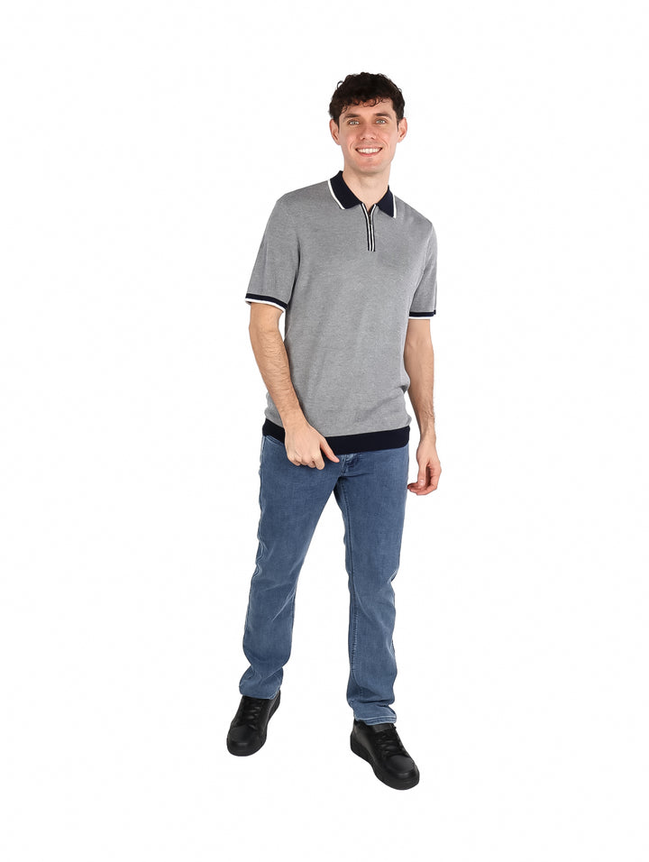 Hombre vistiendo camiseta polo color azul zafiro oscuro con detalles contrastantes en el cuello y mangas.