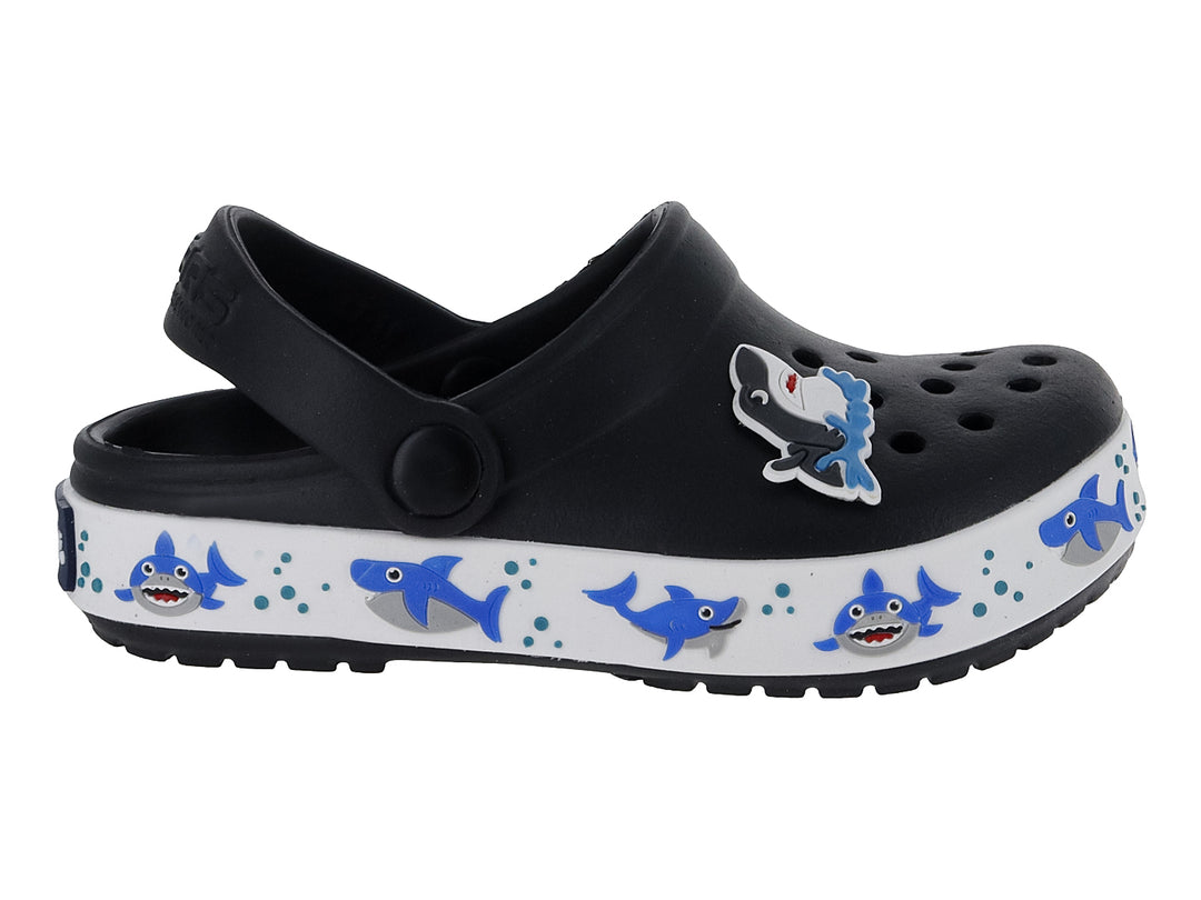 Zueco negro con suela blanca decorada con tiburones azules y un accesorio de tiburón en la parte superior.
