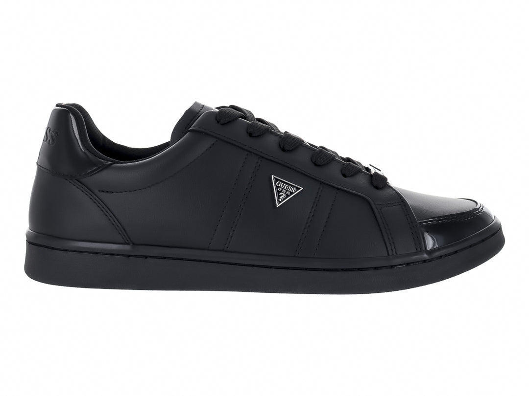 Tenis Guess color negro con suela plana y cordones.