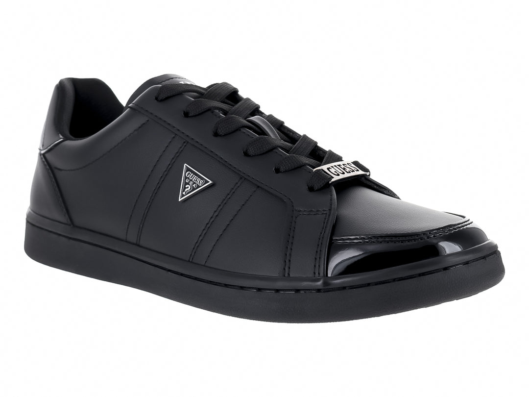 Tenis Guess color negro con suela plana y cordones.