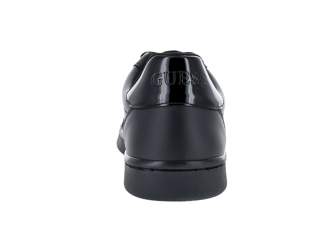 Tenis Guess color negro con suela plana y cordones.