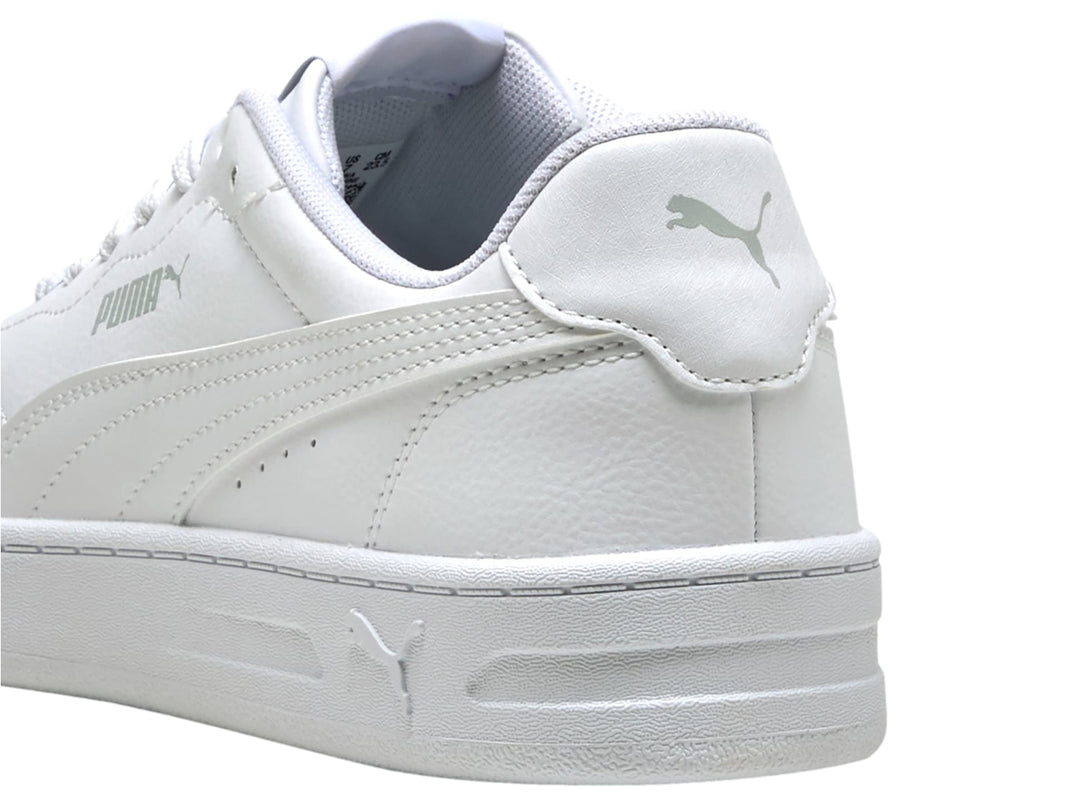 Tenis PUMA blancos de corte bajo con suela plana y cordones, vista lateral.