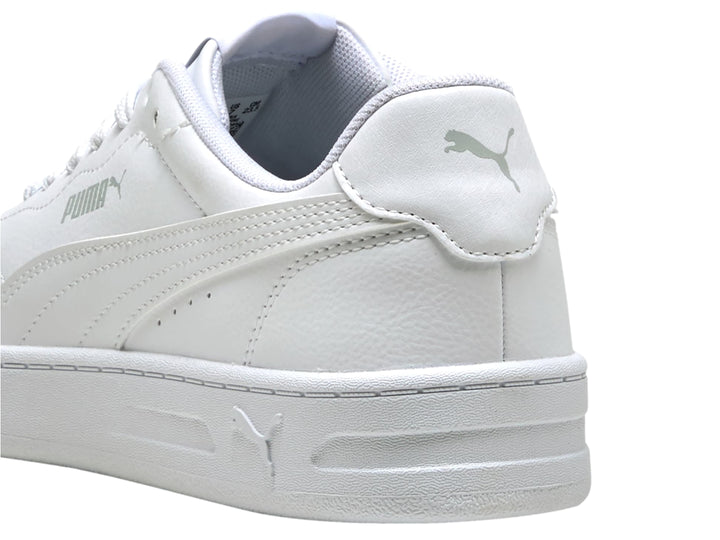 Tenis PUMA blancos de corte bajo con suela plana y cordones, vista lateral.
