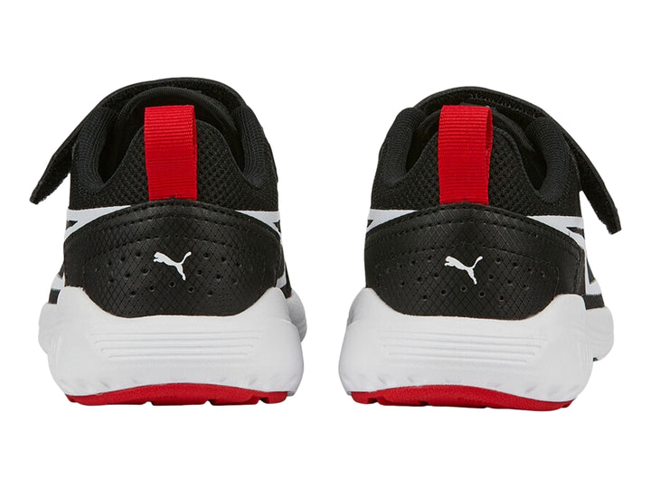 Tenis deportivos PUMA negros con suela blanca y tirador rojo en el talón.