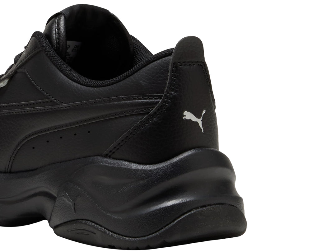 Tenis PUMA color negro con suela gruesa de plataforma, vista lateral.