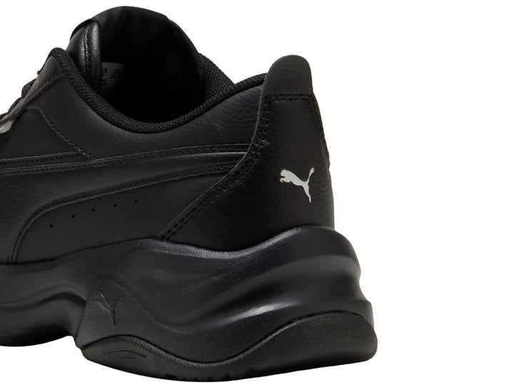Tenis PUMA color negro con suela gruesa de plataforma, vista lateral.