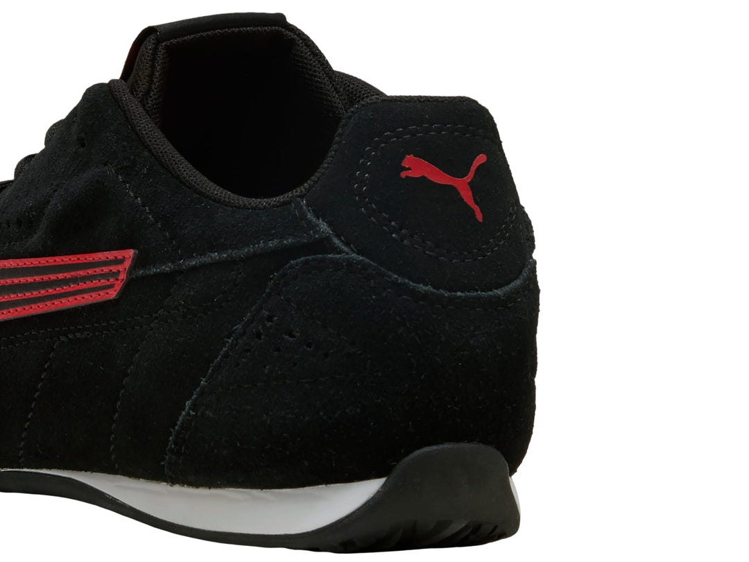 Tenis PUMA CATCH SD en color negro con franja lateral roja y suela blanca en el talón.