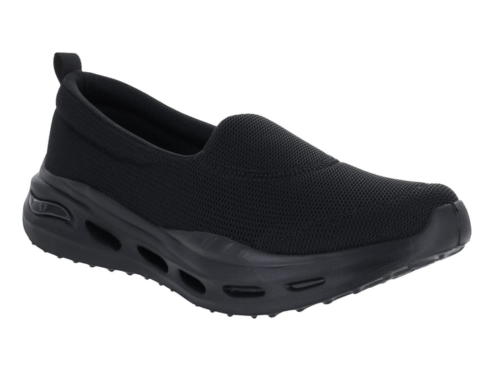 Zapato deportivo negro de estilo slip-on con suela gruesa y tejido transpirable.