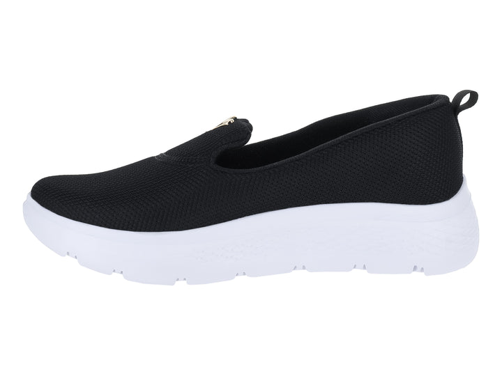Tenis slip-on de color negro con suela blanca gruesa y tejido transpirable.