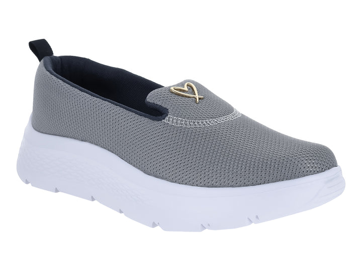 Zapato deportivo slip-on de color gris con suela blanca gruesa y detalle dorado en la parte superior.