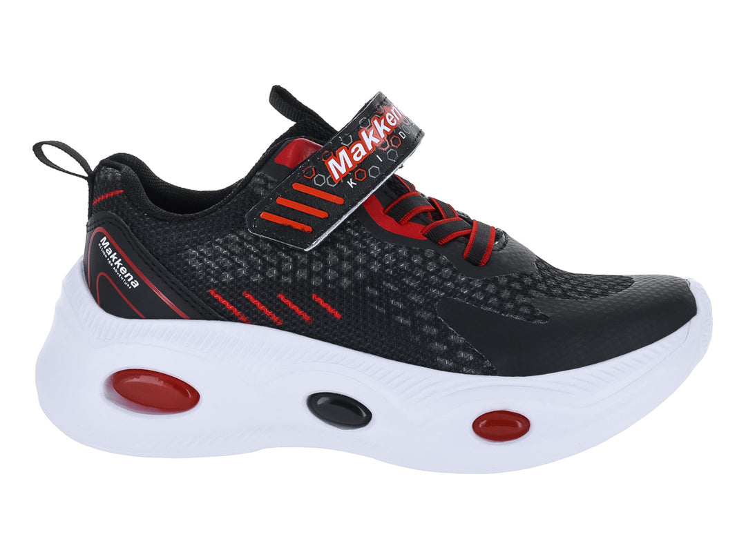 Tenis deportivo infantil color negro con detalles rojos y suela blanca.