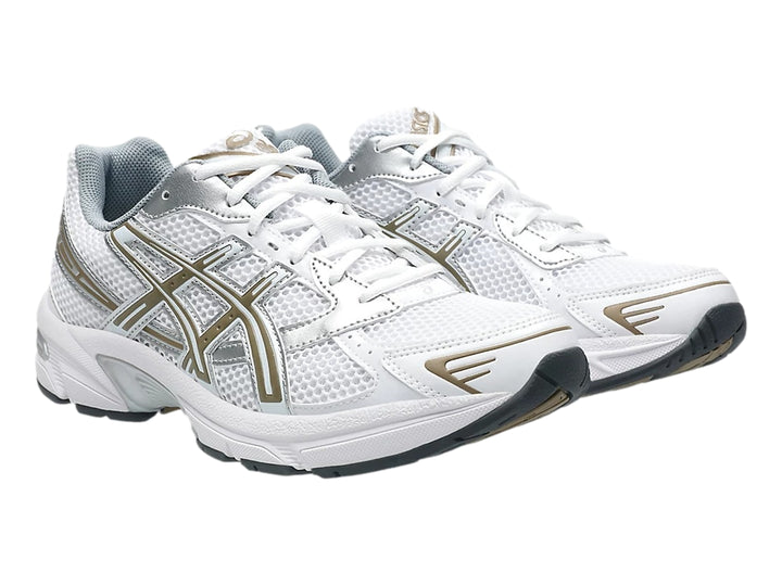 Tenis deportivos ASICS GEL-1130 en color blanco con detalles dorados y plateados sobre fondo blanco.