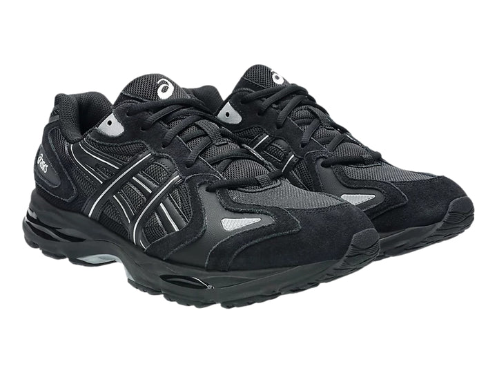 Tenis deportivos ASICS color negro con detalles plateados y suela negra.