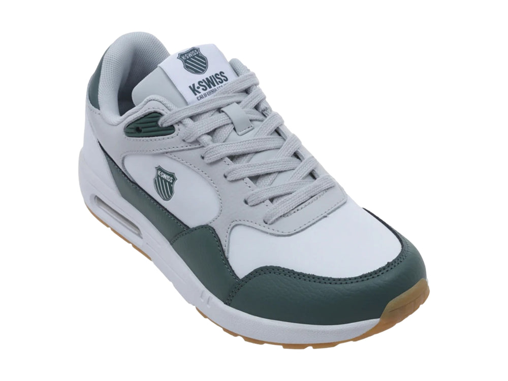 Tenis K-Swiss Maxwell en colores blanco, gris y verde con suela marrón y amortiguación visible.
