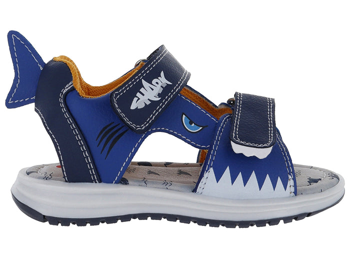 Sandalia infantil azul con diseño de tiburón, suela blanca y cierres de velcro.