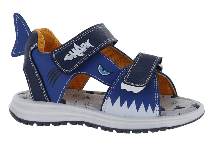 Sandalia infantil azul con diseño de tiburón, suela blanca y cierres de velcro.