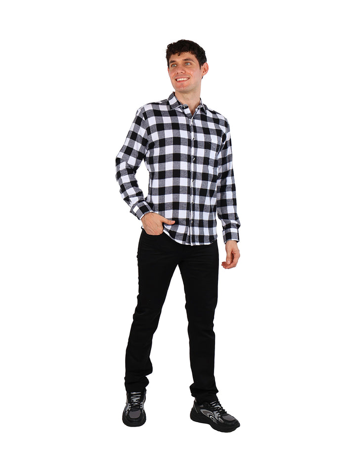 Hombre vistiendo camisa de franela a cuadros en color negro y blanco con pantalones negros.