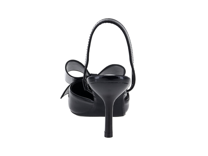 Zapato de tacón negro de charol con moño decorativo y tira trasera.