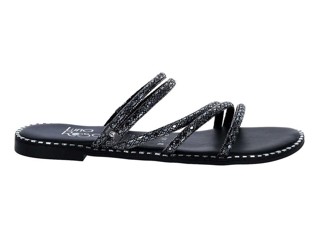Sandalias negras planas con tiras brillantes y detalles plateados en el borde.
