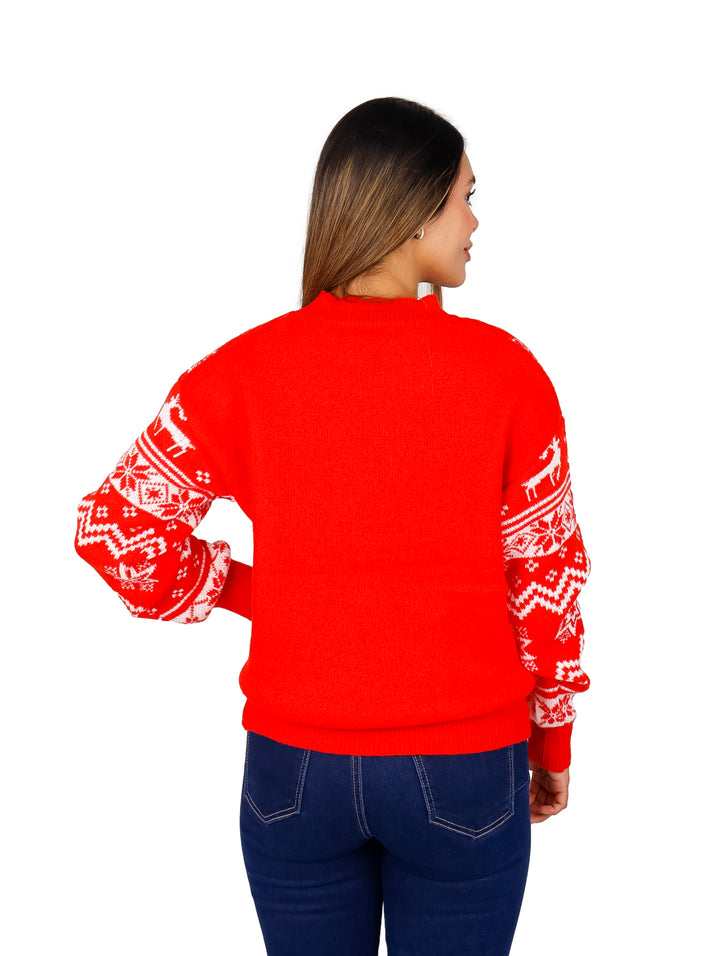 Mujer vistiendo un suéter navideño rojo con patrones blancos de renos y copos de nieve.