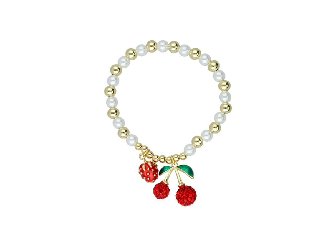 Pulsera dorada con perlas blancas y dijes de cerezas rojas brillantes.