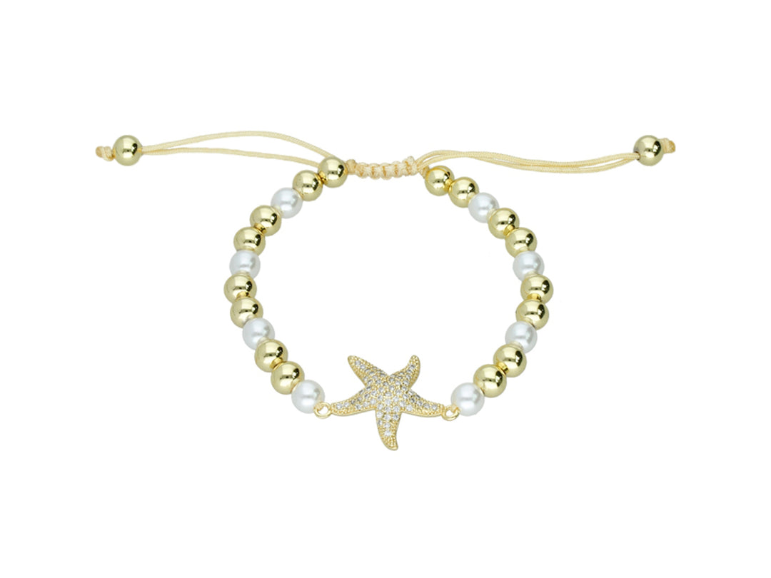 Pulsera dorada con cuentas blancas y un dije central en forma de estrella de mar brillante.