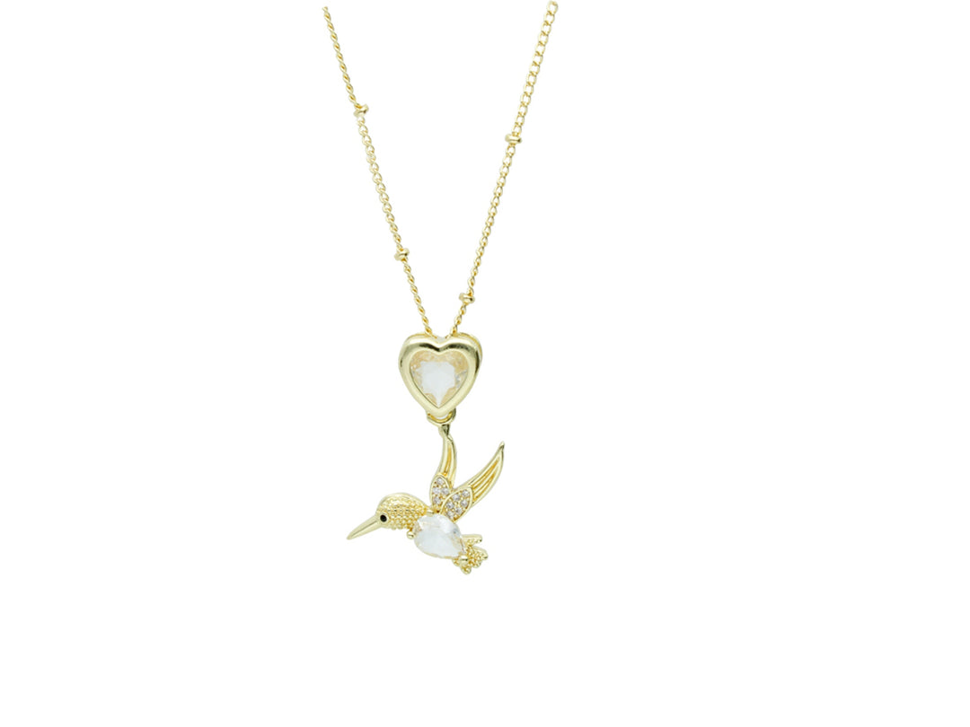 Collar dorado de la marca ROZE con dije de corazón y un colibrí detallado en color blanco y dorado.