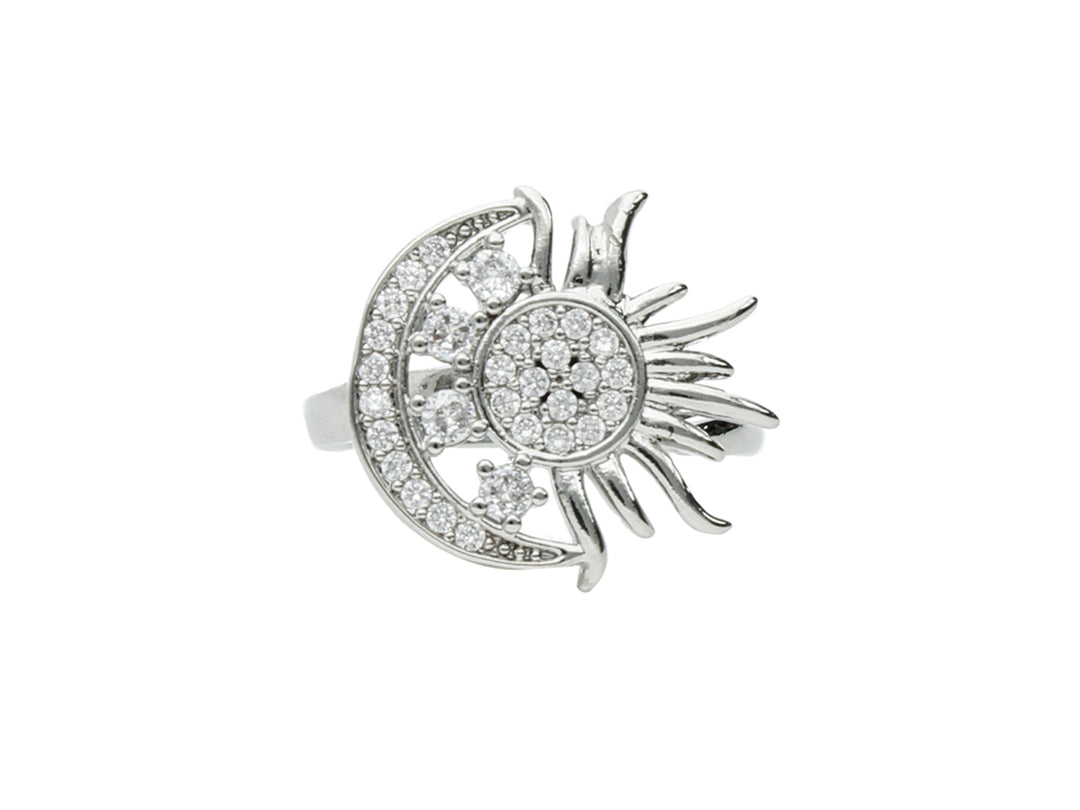 Anillo de plata con diseño de sol y luna adornado con pequeñas piedras brillantes.
