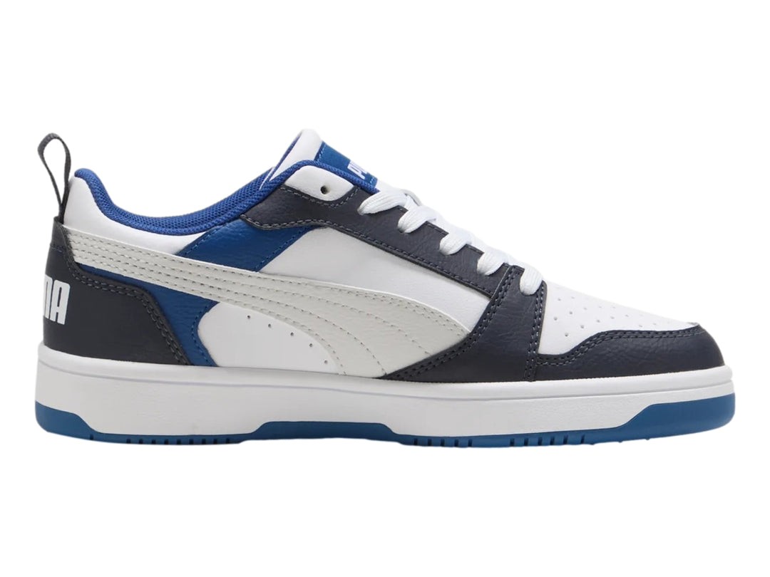 Tenis PUMA Rebound V6 Lo JR color blanco con detalles en azul y negro, diseño deportivo de corte bajo.